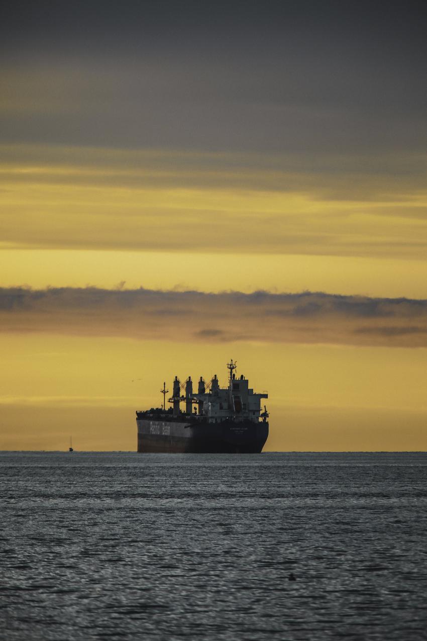 Bulk carrier at anchor at sunset waiting for a berth